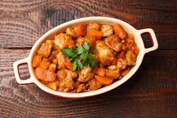 Delicious cooked stew in baking dish on wooden table, top view