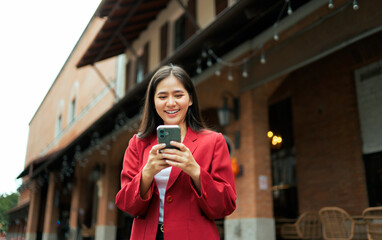 Asian businesswoman using mobile phone in city