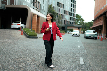 Businesswoman walking in urban setting holding phone