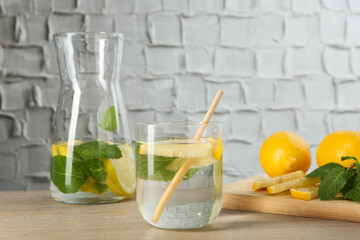 Refreshing water with lemons and mint on wooden table, closeup