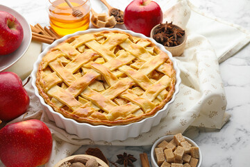 Tasty homemade apple pie and ingredients on white marble table, closeup