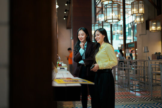 Asian businesswomen colleagues browsing smiling in modern office