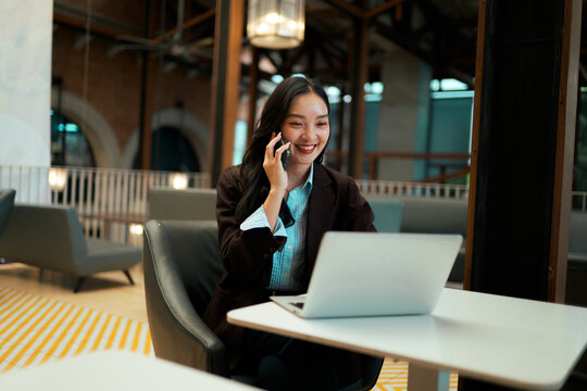 Young Asian woman working at modern office - Powered by Adobe