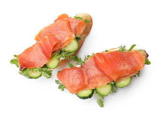 Tasty bruschettas with salmon, cucumber and arugula isolated on white, top view