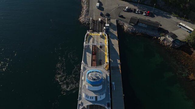 Ro-ro ferry unloading vehicles and people at Norwegian port, aerial view
