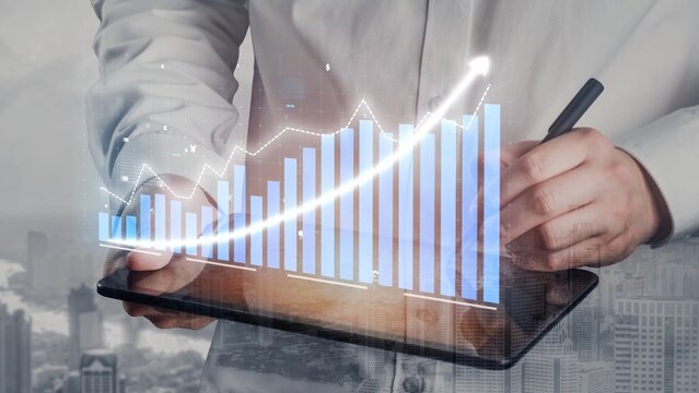 A business professional analyzes data trends using a digital chart displayed on a tablet, set against an urban backdrop featuring office buildings. Copula