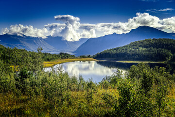 Typical norwegian scenery with a lake and mountains in the background