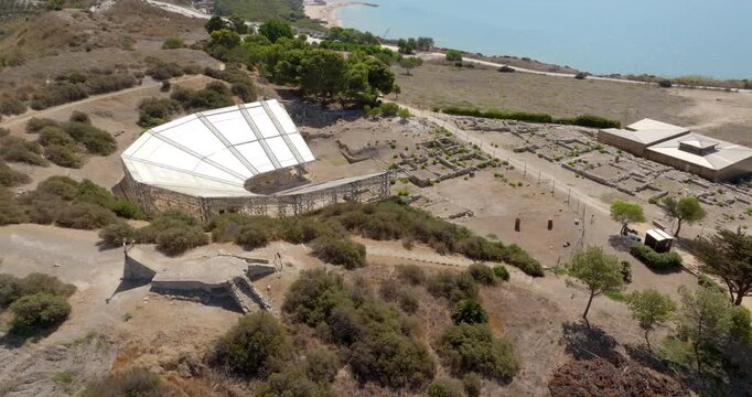 Aerial view of the theater of Eraclea Minoa. It's a ancient Greek theater located in the archaeological site of ​​Cattolica Eraclea, in province of Agrigento, Sicily, Italy. In background is azure sea
