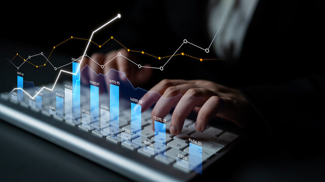 A business professional is typing on a keyboard while analyzing financial graphs and data analytics overlay in a dark setting, symbolizing market trends and investment. Scalp