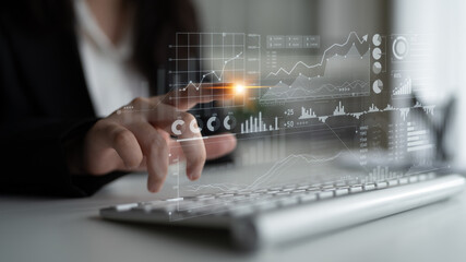 A business professional uses a laptop to analyze data trends on a digital screen, showcasing financial decision making and strategic planning through modern analytics. Scalp