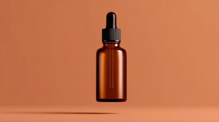 Fototapeta premium Minimalist studio shot of an amber glass dropper bottle floating against a warm terracotta background.