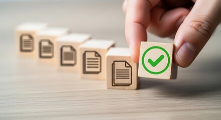 Hand placing a wooden block with a green checkmark on a row of blocks with document icons, symbolizing approval and completion