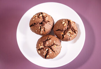 delicious chocolate cupcakes on white plate on pink background