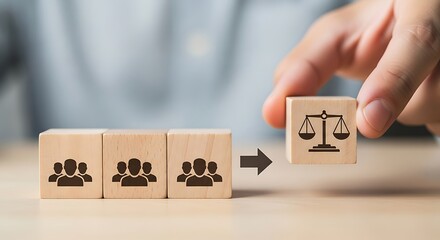 Hand placing a wooden block with scales of justice symbol, representing legal fairness and equality, next to blocks with people icons