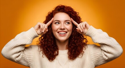 Young woman smiling and thinking on orange background