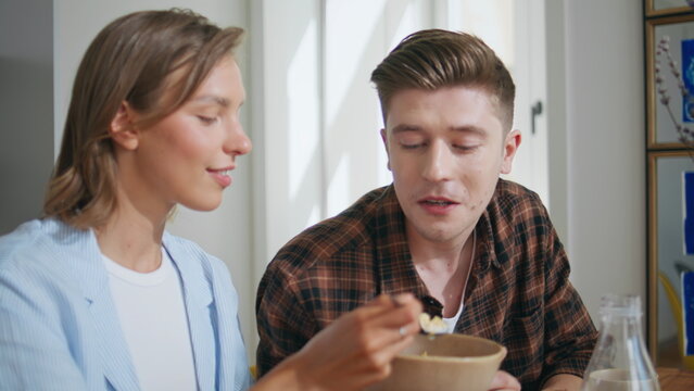 Closeup happy family breakfast together on weekend. Loving girl giving cereal - Powered by Adobe