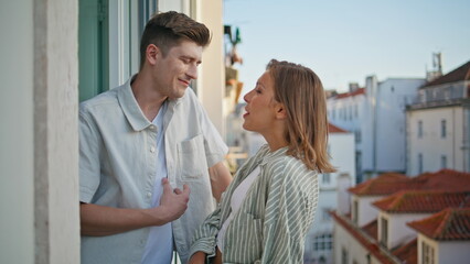 Obraz premium Couple enjoying urban date in evening. Romantic spouses talking on balcony