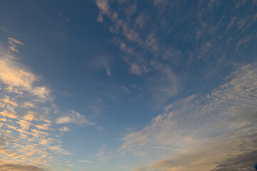 A Beautiful, Serene Sky Filled with Soft, Fluffy Clouds at Dusk as Day Transitions to Night