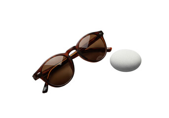 Stylish brown tortoiseshell round-frame sunglasses with dark brown tinted lenses and a pale grey river stone on a solid transparent background, high key studio lighting, luxury eyewear concept