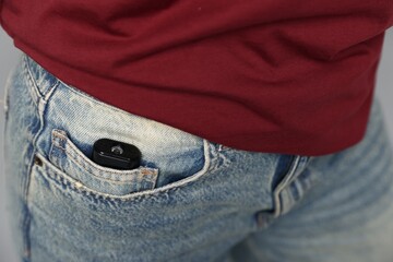 Young woman with hidden spy camera in her pocket, closeup