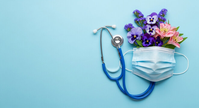 Stethoscope And Medical Mask With Flowers On Blue Background