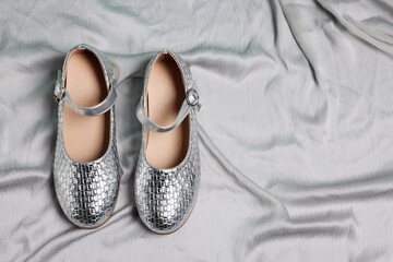 Pair of stylish kid's shoes on grey fabric, flat lay. Space for text