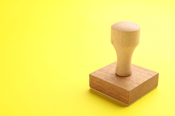 One wooden stamp on yellow background, closeup. Space for text