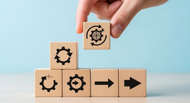 Hand placing a wooden block with gears and arrows representing workflow