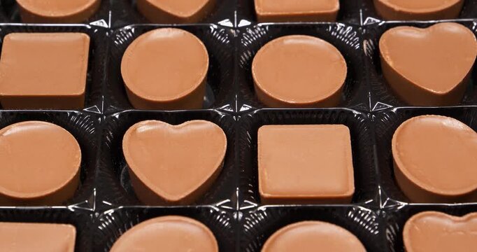 Chocolate candies in a packaging. Valentines Day Gift. Candies are round, square and heart-shaped. Delicious chocolate candy with of different forms, including heart-shaped ones