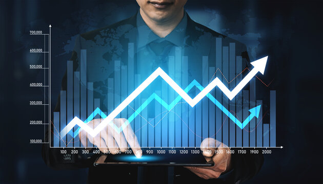 A businessman using a digital tablet to analyze market data, surrounded by graphs that illustrate financial growth and trends in a modern office setting. Scalp - Powered by Adobe