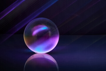 Luminous Sphere. A glowing orb reflects vibrant purple and blue hues on a shiny surface