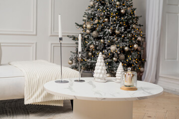 Modern Christmas interior with decorated tree and elegant white decor on coffee table