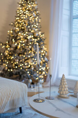 Modern Christmas interior with decorated tree and elegant white decor on coffee table