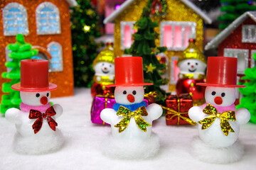 Five snowmen with presents among the houses of a Christmas town