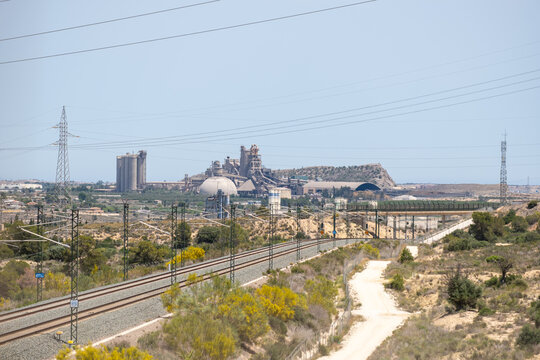 Industrial landscape with railway tracks and power lines in a rural setting