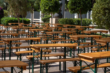 Outdoor picnic area with wooden benches and tables in sunlit park setting