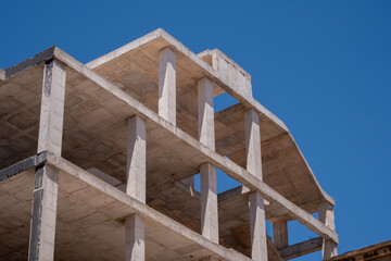 Unfinished concrete building against clear blue sky: urban architecture and modern construction