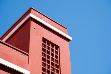 Red architectural detail against bright blue sky