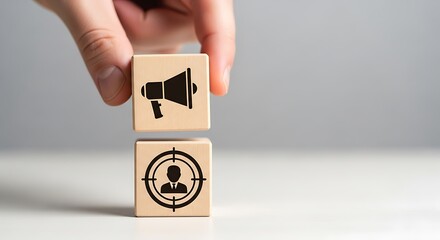 Hand stacking wooden blocks with megaphone and target icons, representing marketing and audience targeting strategy