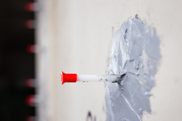 Epoxy injection crack repair on concrete foundation. Close up. Used for sealing and waterproofing walls. Injection ports or packers for professional concrete restoration. Selective focus.