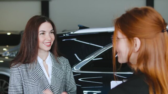 Saleswoman engages with a potential buyer at the dealership as they discuss financing options and finalize details for a car test drive and purchase agreement.
