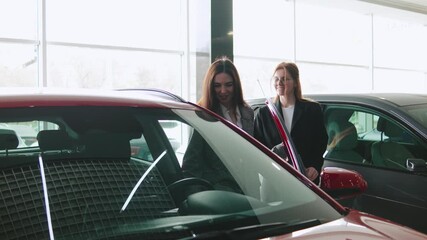 Saleswoman engages with client during consultation at automobile dealership for test drive and vehicle purchase