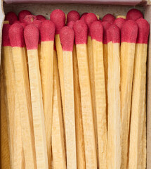 Open box of wooden matches with red heads, top view
