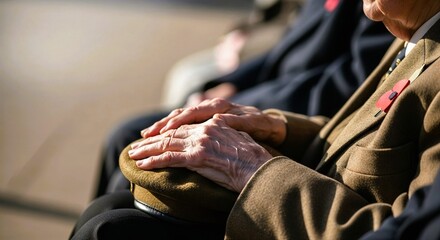 Elderly man resting hands on a hat while seated outdoors during daytime, Remembrance Day    