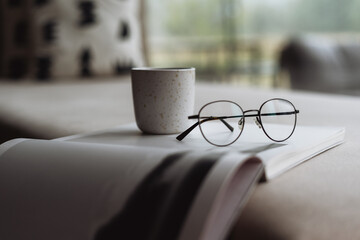 Cozy living room scene with a cup of coffee and reading materials on a table