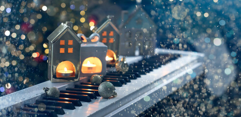 Christmas balls and candles on piano, closeup. Holiday card design with bokeh lights