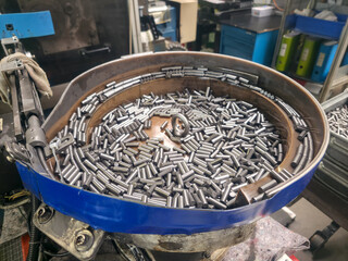 Inside vibrating tumbler at Factory showing pins to be sorted and inspected