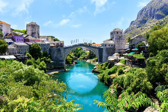 Beautiful view of the Old Bridge in Mostar, Bosnia and Herzegovina, spanning the turquoise Neretva River on a sunny summer day.