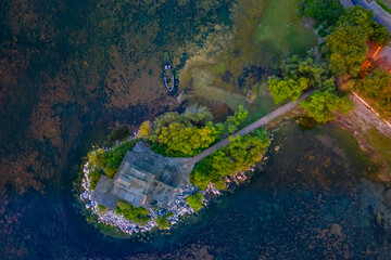Aerial drone view of the beautiful landscape of Shiroka village beside lake at sunset near Shkoder, Albania