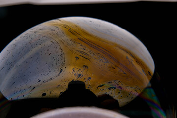 closeup photo of colored light reflection on the surface of soap bubble